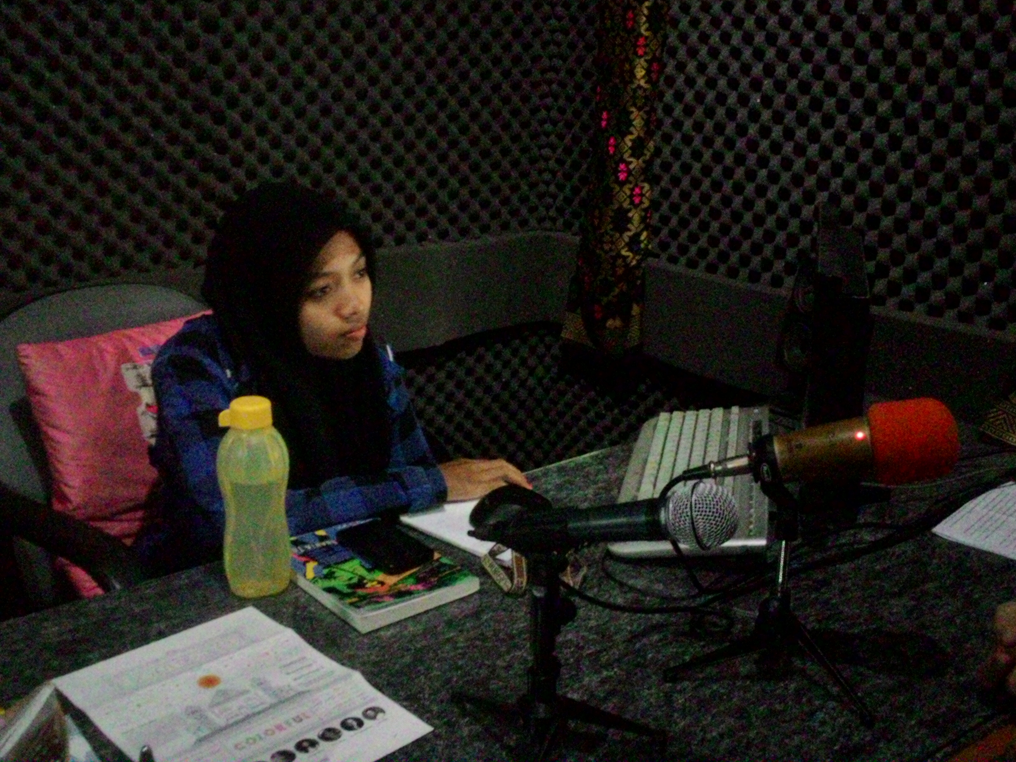Nur Qoidatun, penyiar Radio Buku, sedang menyiarkan program "Musik Senja" yang memutarkan musik-musik intrumental.
