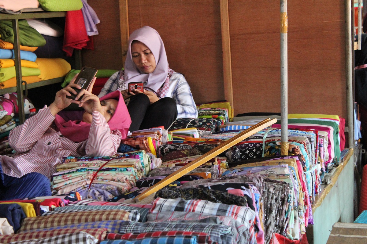 Pedagang kain di Pasar Pagi bersantai sejenak di lapaknya sembari menunggu pembeli datang pada Minggu (15/11). 